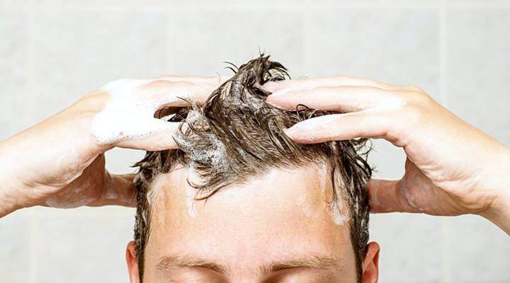 Close-up of hands gently massaging shampoo into wet hair.